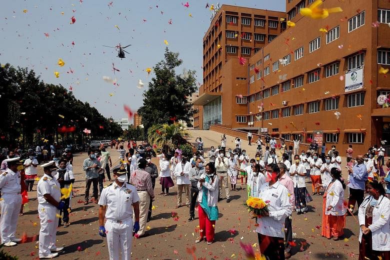 An Indian Navy Chetak helicopter showering flower petals yesterday over the premises of a hospital in Visakhapatnam as part of an event showing gratitude to the front-line warriors fighting the coronavirus outbreak in the country.