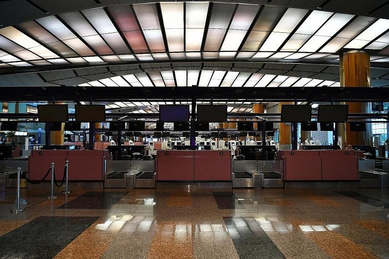 Empty check-in counters at Changi Airport Terminal 2 last week. The number of visitors to Singapore plummeted to about 240,000 in March, the lowest since the Sars outbreak. ST PHOTO: LIM YAOHUI