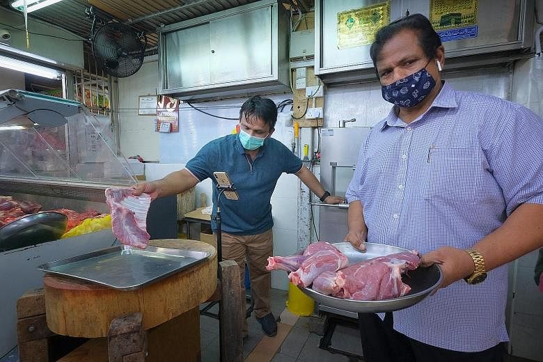 People at Tekka Market yesterday afternoon. Some stalls have reported sales plummeting by up to 80 per cent amid the pandemic. ST PHOTO: GAVIN FOO Mr Mohamed Mustafa Shahul Hamid (at right), who runs a mutton stall at Tekka Market, and his son Nizamd