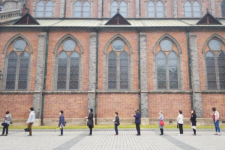 People observing social distancing outside a Catholic church in Seoul yesterday. South Korea has observed strict social distancing since March, but the country appears to have brought its Covid-19 outbreak under control.