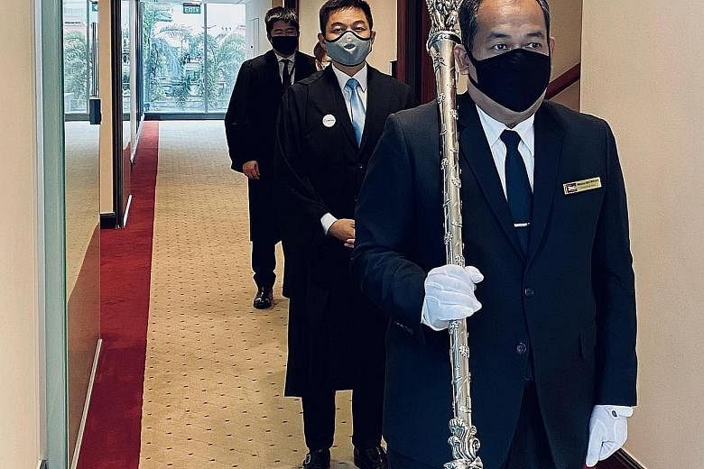 From front to back: The Serjeant-at-Arms shouldering the mace, a symbol of the Speaker's authority, Speaker of Parliament Tan Chuan-Jin, the Clerk of Parliament (partially hidden) and an assistant clerk before they entered the Chamber yesterday.