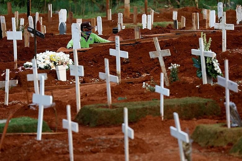 A worker at a cemetery for Covid-19 victims in Jakarta. Experts worry that the pandemic may spread out of the big cities and into villages, where medical services are scarce.