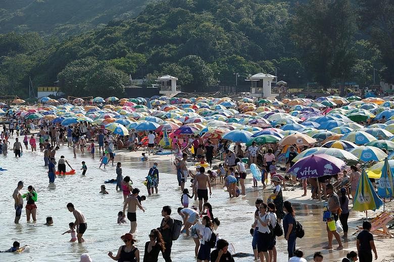 Hong Kong residents packing a local beach on Sunday. Chief Executive Carrie Lam has announced that the current limit on public gatherings of groups of up to four people will be raised to eight from Friday. PHOTO: REUTERS