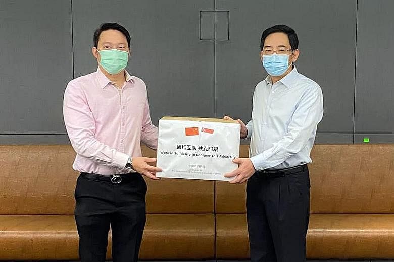 Senior Minister of State for Health Lam Pin Min (left) receiving a donation of masks from China's Ambassador to Singapore Hong Xiaoyong at the Ministry of Health yesterday.