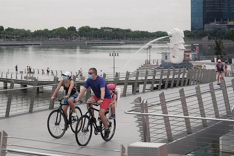 People cycling at Jubilee Bridge at the weekend. Yesterday was the 13th day in a row with new daily cases below 1,000. The total number of coronavirus cases in Singapore now stands at 20,198. ST PHOTO: GAVIN FOO