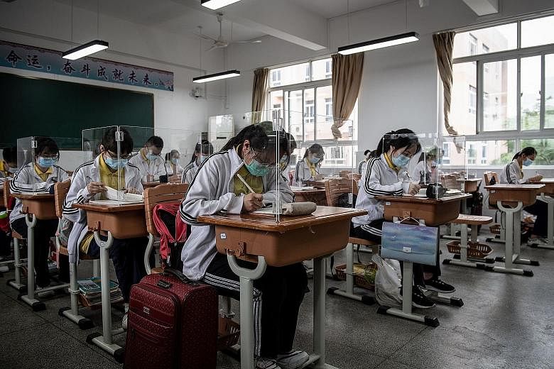 High school senior students studying in a classroom with safety measures in place in Wuhan, China's Hubei province, yesterday. Only the province's oldest students were back in school yesterday - vocational students and seniors who are due to take the