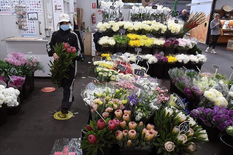 A florist in Melbourne making preparations for Mother's Day as Australia's government unveiled a three-stage plan yesterday to fully reopen the coronavirus-hit economy by July. The Reserve Bank of Australia has forecast that the economy would shrink 