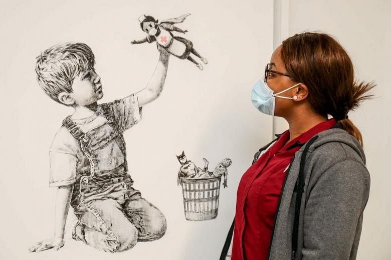 Banksy’s new artwork Game Changer shows a boy playing with a nurse superhero toy, with figures of Batman and Spiderman discarded in a basket. 