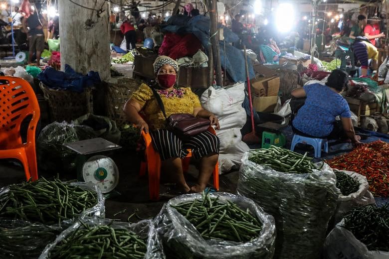 A vegetable vendor waiting for customers on Thursday at a market in Medan in Indonesia's North Sumatra province, as businesses struggle to survive amid strict social distancing rules.