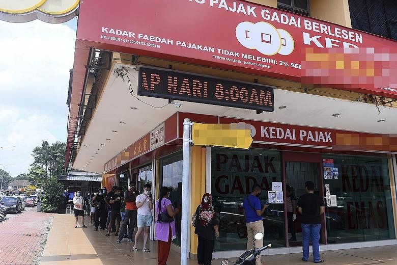 Long queues were seen outside pawnshops in Johor (above), Selangor, Melaka and other states in Malaysia as people pawned their jewellery for cash or renewed pawn tickets. Malaysia began relaxing its coronavirus control measures, allowing some busines