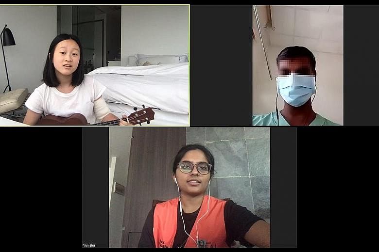Alexandra Hospital volunteer Hannah Chen performing a medley of songs for Mr Murugam Pillai (not his real name), while another volunteer S. Venisha translates. Mr Pillai is one of 360 migrant workers with Covid-19 who have been warded in the hospital