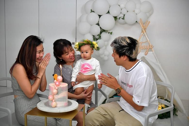 Above: Madam Lim Bee Wah, 56, quit her job of 14 years last year so her daughter Tam Xiang Ying, 32, seen here with husband Kelvin Chua, 36, and daughter, Faye, would not have to give up her job to care for the baby. ST PHOTO: NG SOR LUAN