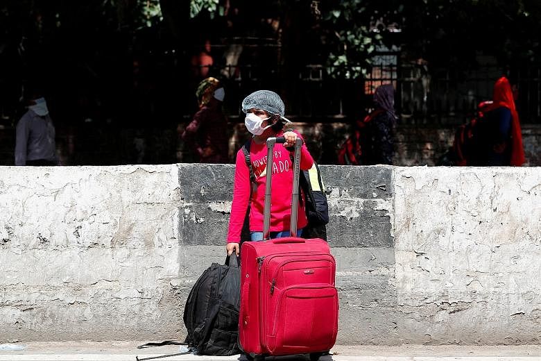 A masked girl outside a New Delhi train station yesterday as India's state-owned railways restarted some services. PHOTO: REUTERS