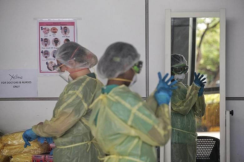 Healthcare workers donning their protective gear at the community isolation facility at Singapore Expo. Unlike Sars, which caused about 800 deaths, Covid-19 has caused a far higher death toll, with nearly 300,000 dead around the world so far. Scienti