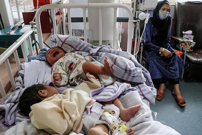 A woman with two newborn babies who lost their mothers following a suicide attack on a Kabul maternity hospital. The Afghan government has decided to resume offensive operations against the Taleban following two attacks, including the hospital attack