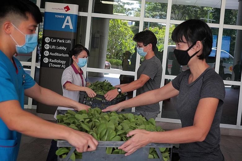 (From far right) Ms Tan Kor Hoon and Mr Chee Zhi Kin of City Sprouts, an urban farming social enterprise, donating vegetables to Ng Teng Fong General Hospital housekeeping supervisor Loo Siew Chein and senior staff nurse Glen Li at the hospital yeste