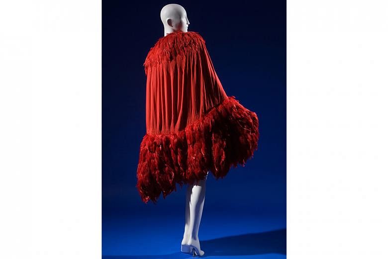 EXHIBIT ON SHOW: A Chanel red silk crepe de chine and feather evening cape (1927, left).