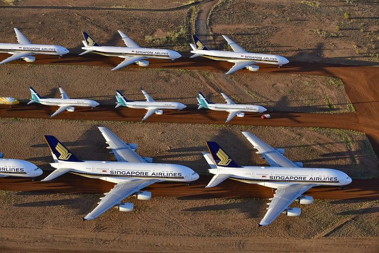 Airplanes belonging to Singapore Airlines (SIA) as well as its subsidiaries SilkAir and Scoot are parked at a storage facility in Alice Springs, Australia, as the coronavirus pandemic causes a steep drop in air travel. SIA reported a full-year loss i