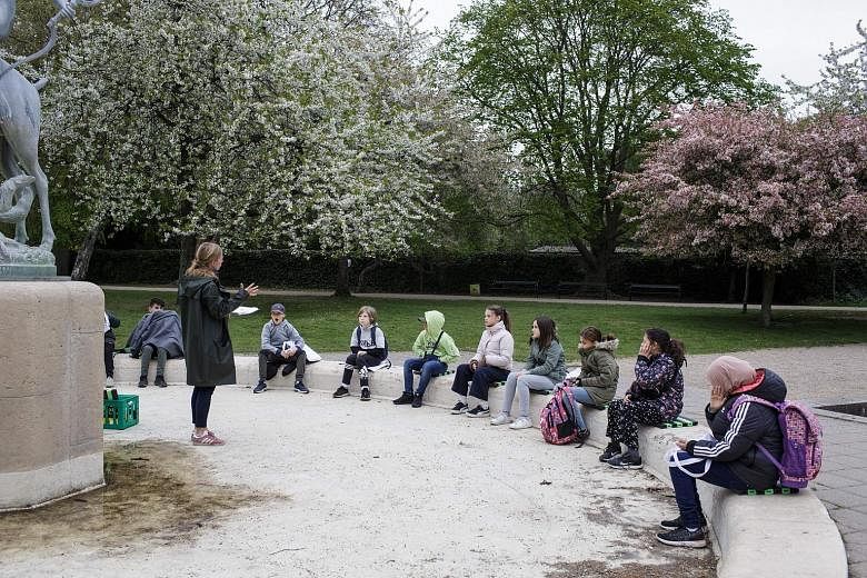 DENMARK: A teacher speaking with her pupils outside a park in Copenhagen last month. In addition to practising safe distancing and regular hand washing, classes must be held outdoors as much as possible. CHINA: In a viral video viewed more than seven