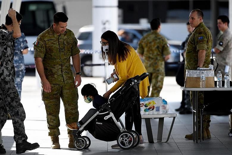 Australian residents being helped by military staff after arriving at the Sydney airport during the pandemic. The Morrison government has called for an international inquiry into the origins of the coronavirus.