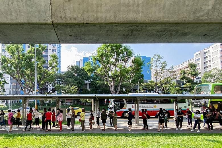 Pre-school staff queueing at Khatib MRT station to board shuttle buses to one of four allocated centres for Covid-19 swab tests on Friday. PHOTO: LIANHE ZAOBAO