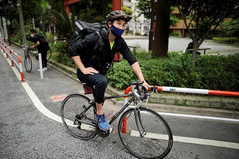 Japan's Olympic fencing medallist Ryo Miyake setting out on another Uber Eats trip around Tokyo last Tuesday amid the coronavirus crisis. His temporary job keeps him in decent financial and physical shape. PHOTO: REUTERS