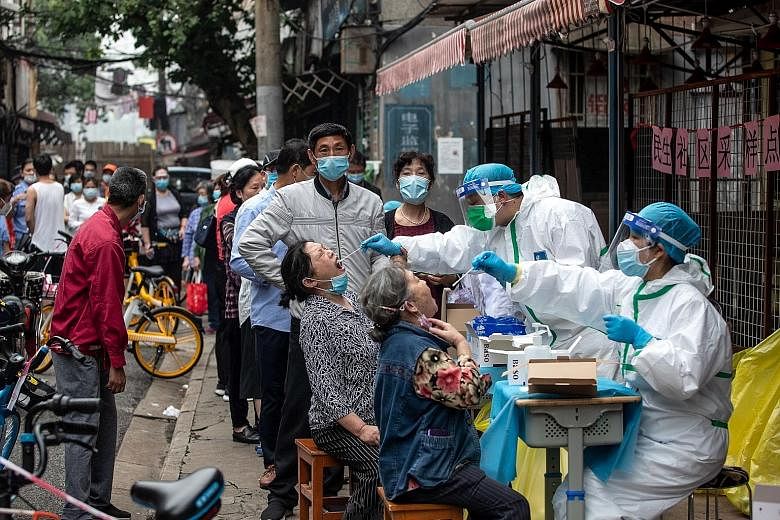 Medical workers taking swab samples from residents for Covid-19 testing in a street in Wuhan on Friday. Safety has become a hot topic on social media among the 11 million residents of Wuhan, as well as among people crowding the test centres, who expr