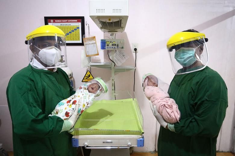 Doctors in protective gear with newborn babies wearing face shields as measures against Covid-19 in the Indonesian province of Aceh last month. Indonesia is anticipating a baby boom as a result of stay-home measures to curb Covid-19 transmissions.