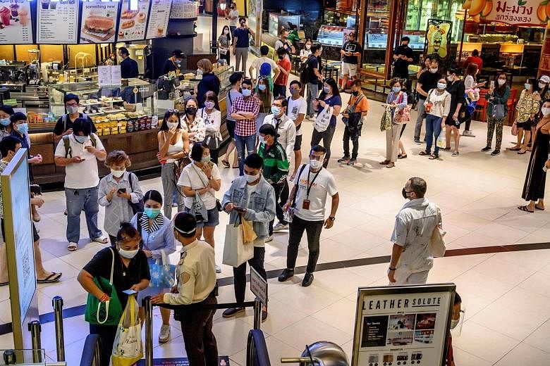 People waiting to enter Siam Paragon in Bangkok on Sunday, the first day Thailand's malls reopened after they were closed in March. With the pandemic hitting domestic activity and tourism, the state planning agency now forecasts a contraction of 5 pe