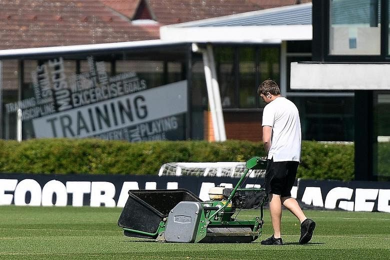 A Watford groundsman preparing the pitches at their training complex in London Colney yesterday. No more than five players will be allowed per field when English Premier League players resume training in small groups today. PHOTO: EPA-EFE