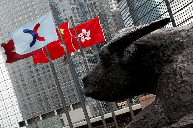 A flag bearing the Hong Kong Exchanges and Clearing logo. The delay in settling IPOs in Hong Kong, which saw HK$314 billion (S$57.4 billion) in such deals last year, has long been a headache for investors and policymakers. PHOTO: REUTERS