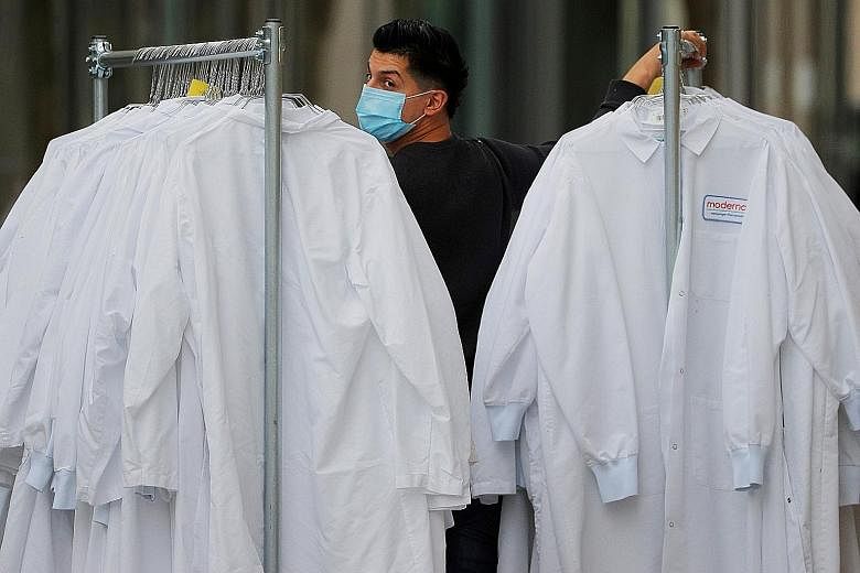 A worker delivering protective lab coats to the headquarters of Moderna, which is developing a vaccine against the coronavirus, in the US state of Massachusetts. The Moderna vaccine is one of more than 100 under development intended to protect agains