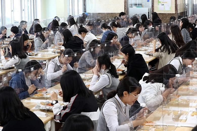 Students having lunch behind transparent protective dividers at a high school in Daejeon city, South Korea, yesterday. PHOTO: AGENCE FRANCE-PRESSE
