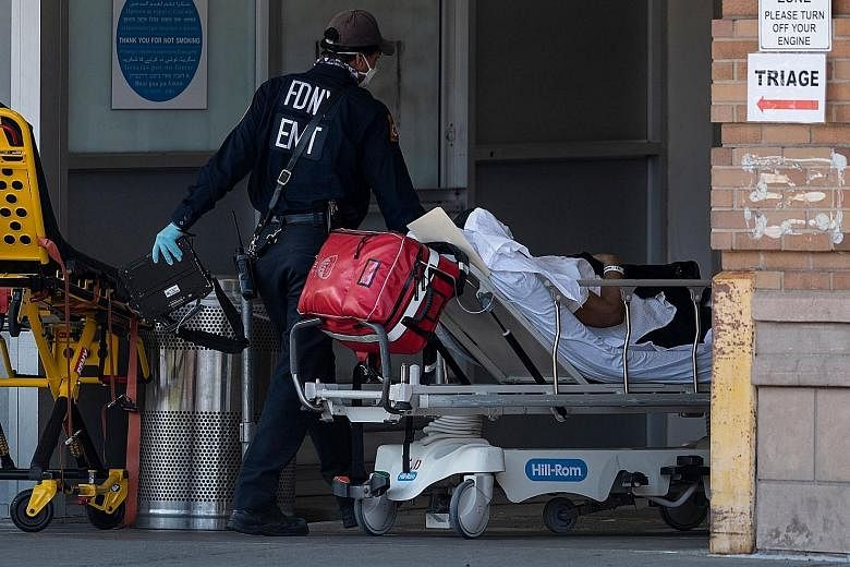 A medical worker wheeling a patient into a special Covid-19 illness area last Sunday at Maimonides Medical Centre in Brooklyn, New York City. Coronavirus-related deaths among Americans are projected to surpass 113,000 by mid-June.