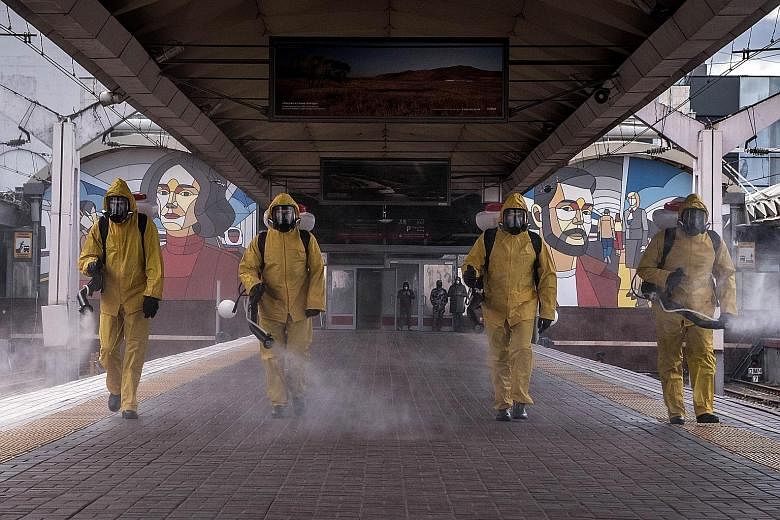Workers in protective equipment spraying sanitiser at Moscow Leningradsky railway station in Moscow on Tuesday. The Russian capital, the country's worst-hit region, is now in its eighth week of coronavirus lockdown.