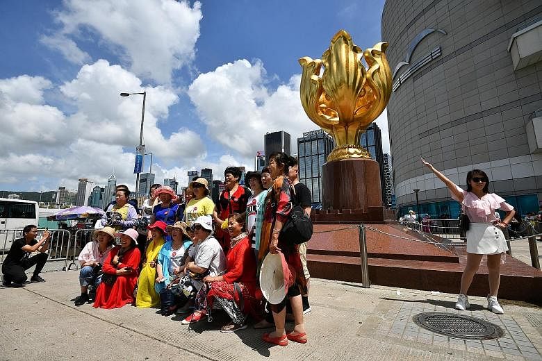 Chinese tourists taking photos at Golden Bauhinia Square in Hong Kong last year. A controversial national security law is expected this year that analysts say will herald more political turbulence for the territory. ST PHOTO: LIM YAOHUI