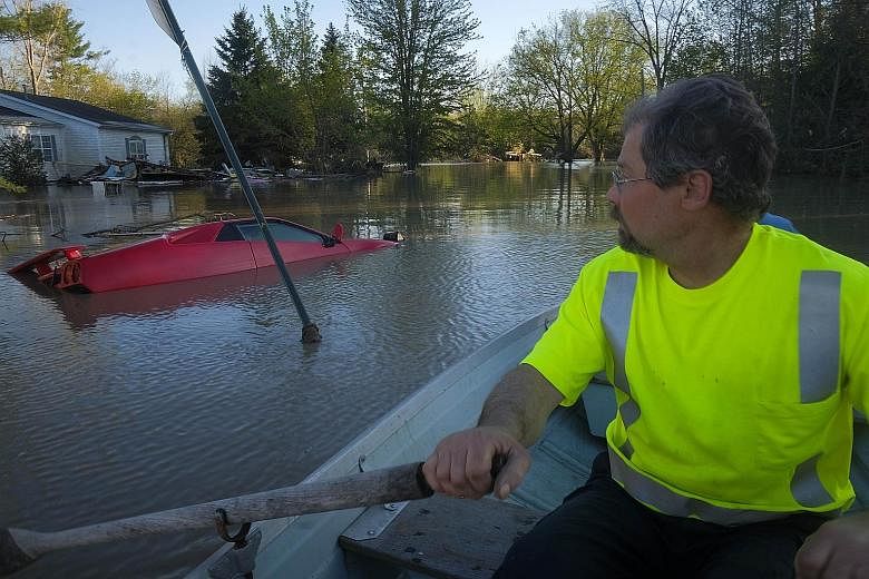 A resident of Sanford village in Midland inspecting the damage in his neighbourhood after floodwaters released by two dam failures submerged parts of the central Michigan town on Wednesday.