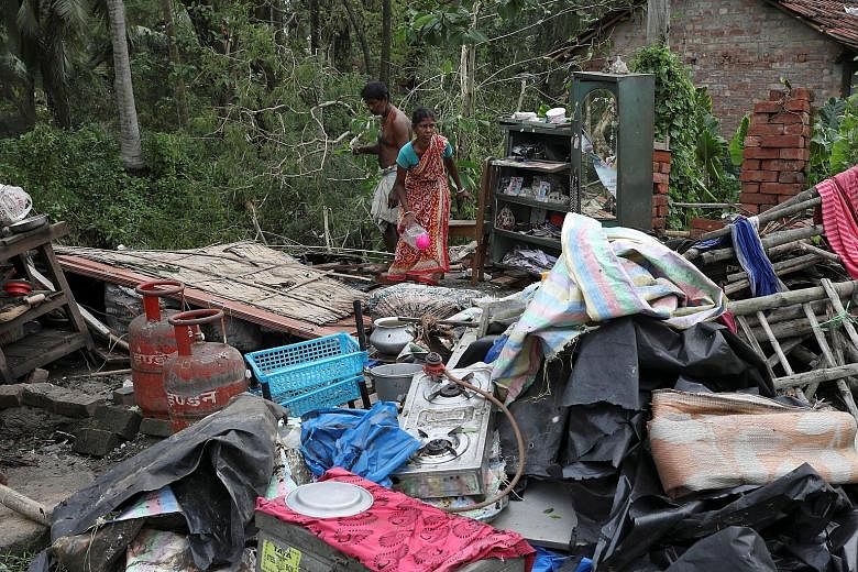 Residents salvaging their belongings from the rubble of a damaged house in the aftermath of Cyclone Amphan in West Bengal, India, yesterday.