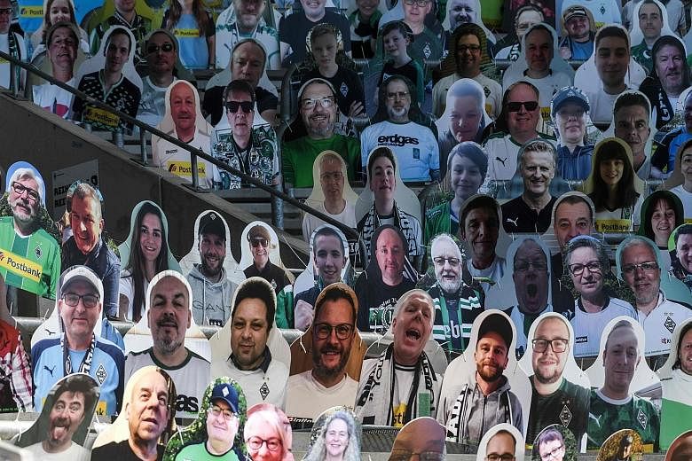 Cardboard cut-outs with portraits of Monchengladbach supporters at the Bundesliga side's ground on Tuesday. These and other gimmicks such as piped-in crowd noise are a poor substitute for live roaring fans.