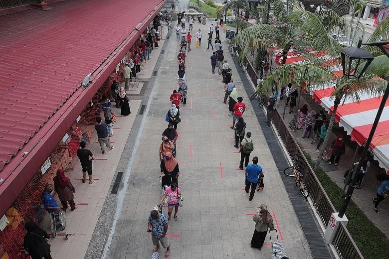 A long queue formed outside Geylang Serai Market yesterday as shoppers waited to enter the popular wet market ahead of Hari Raya Aidilfitri celebrations tomorrow. The queue spilled over to the pedestrian walkways as people lined up to purchase necess