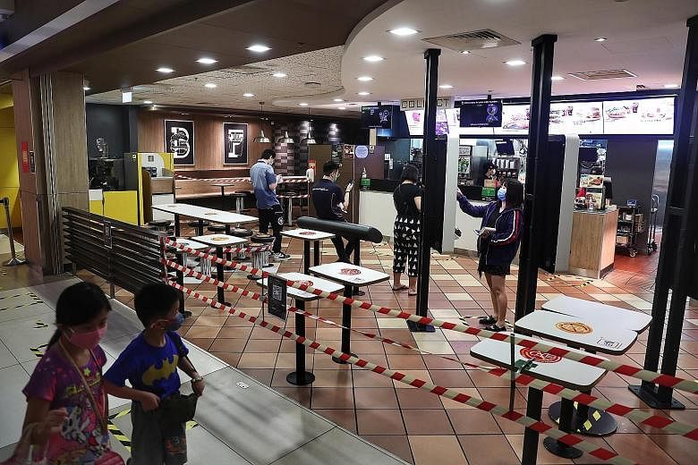 Customers at a McDonald's outlet at IMM yesterday. Given the restrictions that have been imposed, Singaporeans have been very resilient, and are complying with all the social distancing and circuit breaker rules, said President Halimah Yacob. ST PHOT