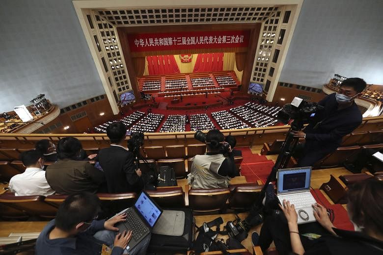 Top: Journalists covering the opening session of China's National People's Congress at the Great Hall of the People in Beijing yesterday. Above: Chinese President Xi Jinping, being served tea, and Premier Li Keqiang during the session. Some 5,000 del
