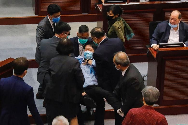 Pan-democratic legislator Hui Chi-fung being removed from a Legco meeting in Hong Kong yesterday, after he scuffled with security officers while protesting against Beijing's move to directly enforce a national security law. PHOTO: REUTERS