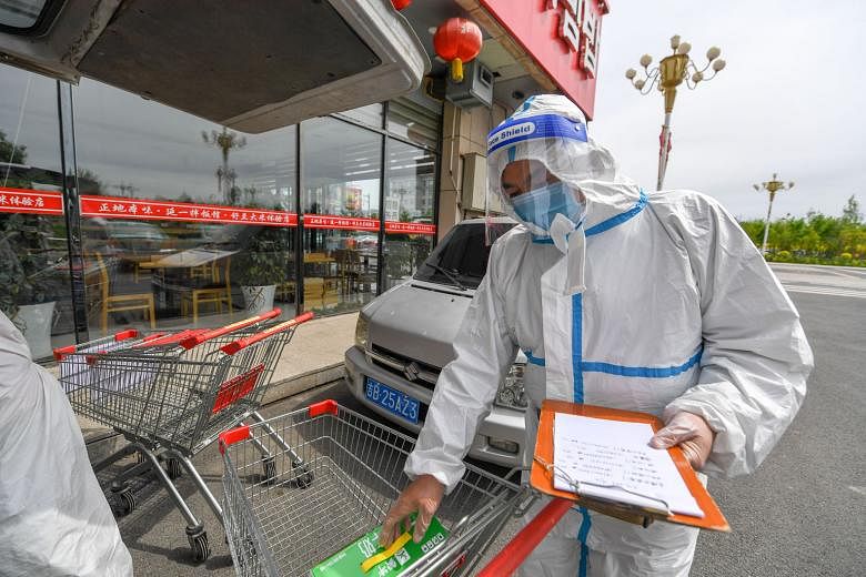 A supermarket employee checking delivery orders in Shulan, Jilin province, on Wednesday. Residential districts with confirmed and suspected cases are completely locked down and daily supplies are delivered to residents. One of the first reported clus