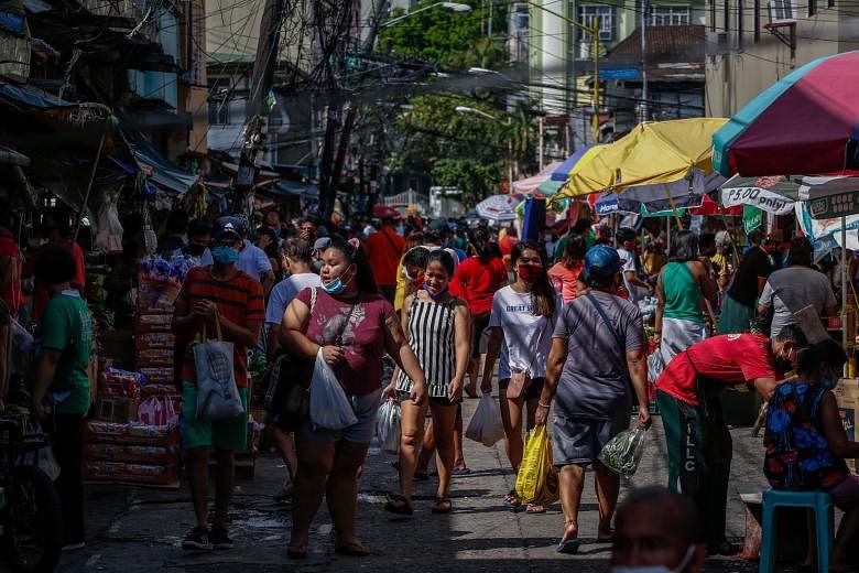 People shopping at a public market in Makati city, south of Manila, last week. The Philippine government this week allowed a host of companies to reopen in the country, but with only half their usual workforce. Malls have also reopened, but most of t