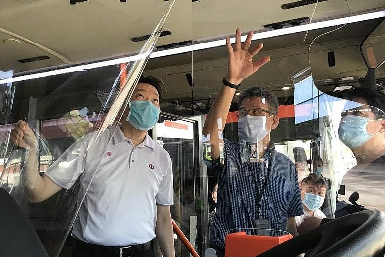 National Transport Workers' Union executive secretary Melvin Yong checking out a transparent shield that is being explored as a means to separate bus drivers from commuters. The union's other safe distancing measures include separators on tables at i