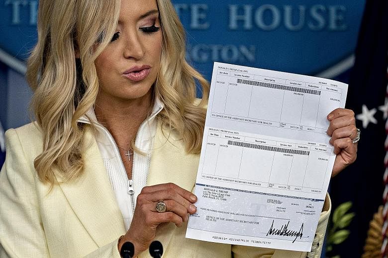 White House press secretary Kayleigh McEnany with US President Donald Trump's cheque for US$100,000 - to be donated from his salary - on Friday. His private bank account and routing numbers were visible.