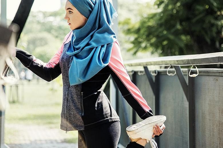A Muslim woman stretching after a workout at the park. For some, faith and fitness intersect in the form of Ramadan boot camp workouts and Christian detox diets. PHOTO: ISTOCK