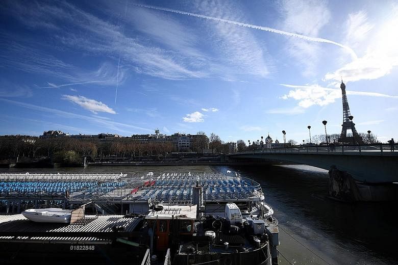 A picture taken on March 15 shows an empty "Bateaux Mouches" tourist boat on the Seine River near the Eiffel Tower in Paris amid the Covid-19 outbreak. The writer says she has taken a real secret pleasure in rediscovering the beautiful buildings and 
