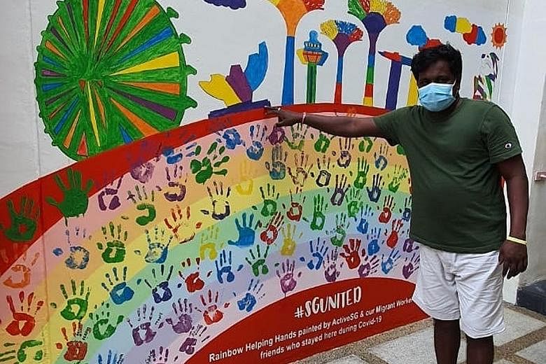 Indian Vasamsetti Durgarao, 40, posing with the wall mural that he helped paint at the Hougang Sport Centre as part of a two-day mural painting session for 125 migrant workers and 10 ActiveSG staff. 